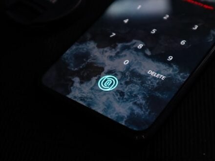 A glowing fingerprint sensor icon on the screen of a dark smartphone